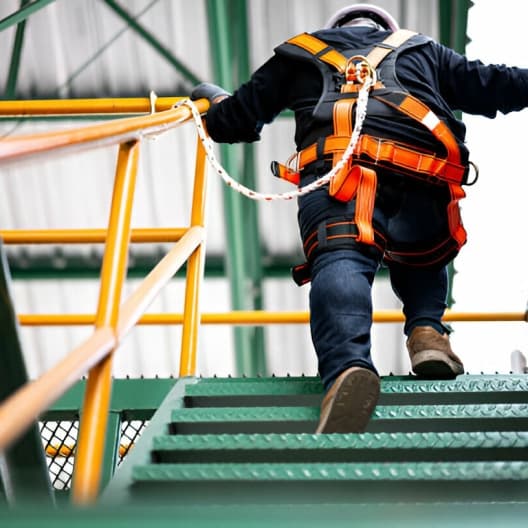 Worker climbing industrial access stairs